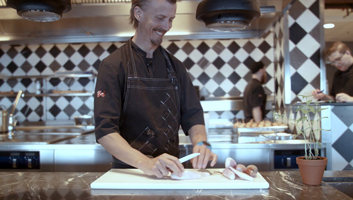 Foto. Paul Svensson står och hackar lök.